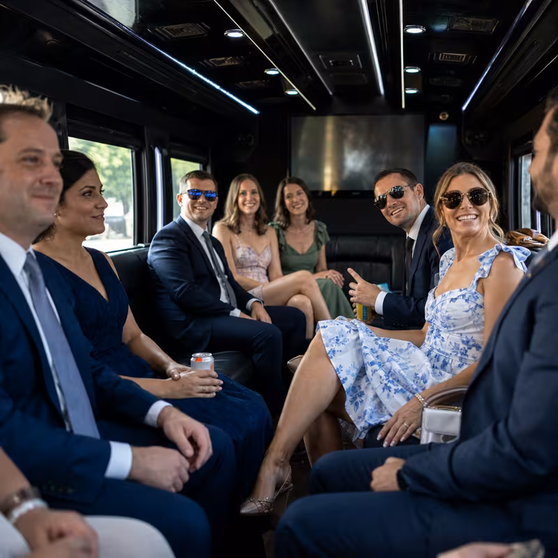 Wedding guests seated inside a Dallas party bus