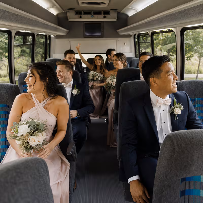 Group boarding a white charter bus for Wedding Transportation transportation in Dallas