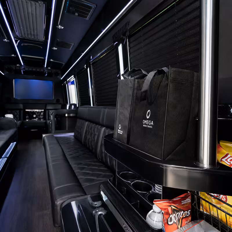 Party bus interior with wraparound leather seating and LED lighting in Dallas